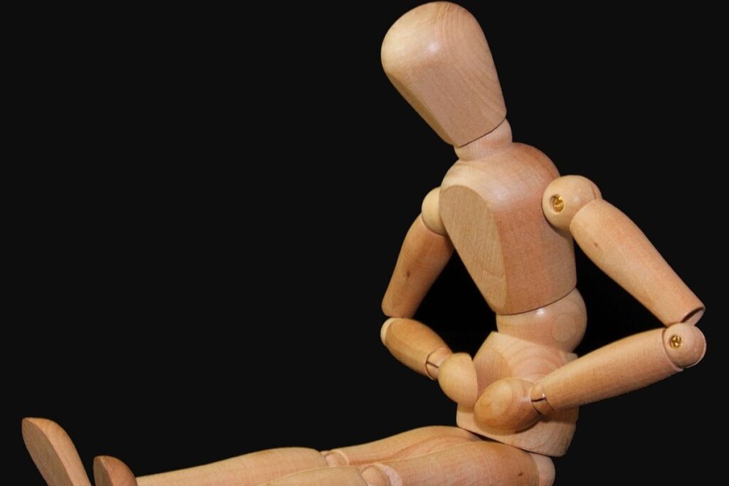 holzfigur mit bauchschmerzen